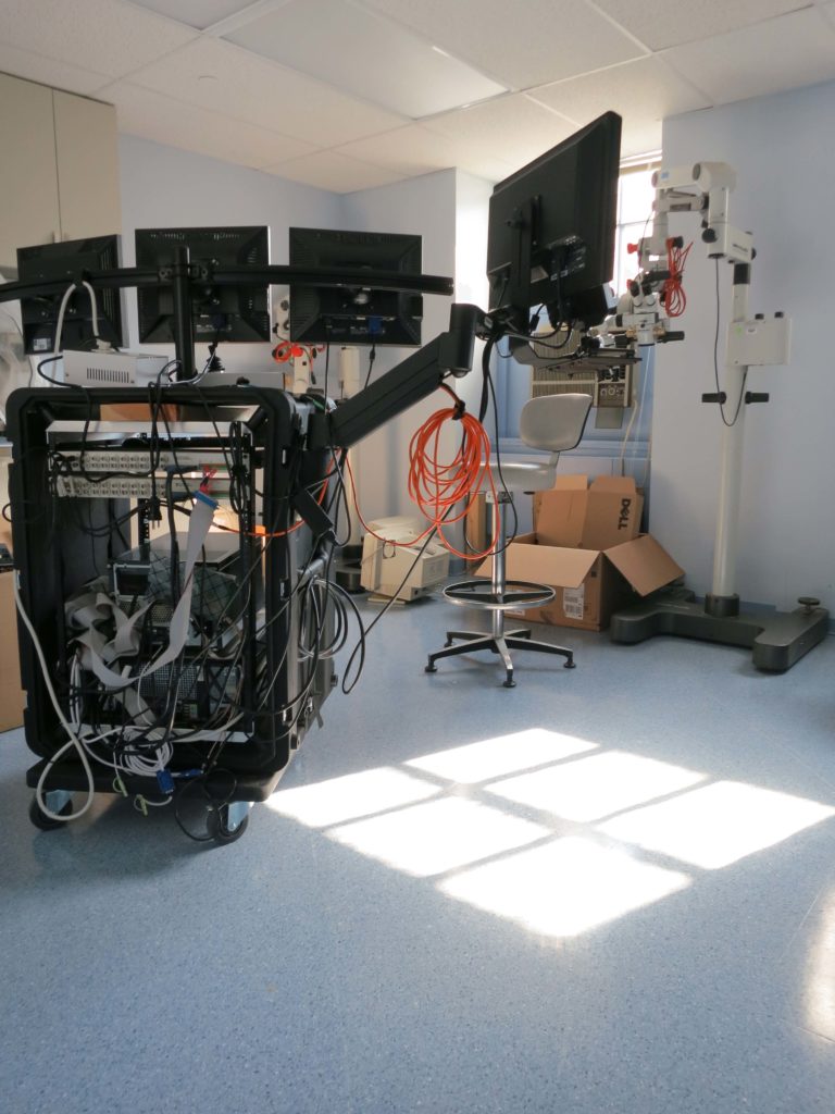 The experimental apparatus. The far right screen is used for video presentation while the others are used for eye tracker calibration and by clinicians.